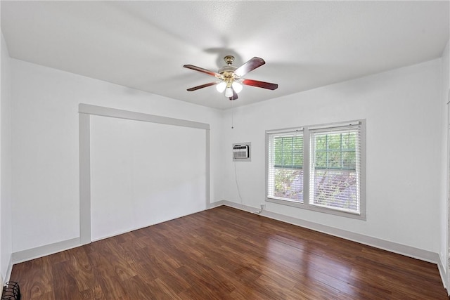 unfurnished room with a wall mounted AC, ceiling fan, and dark wood-type flooring