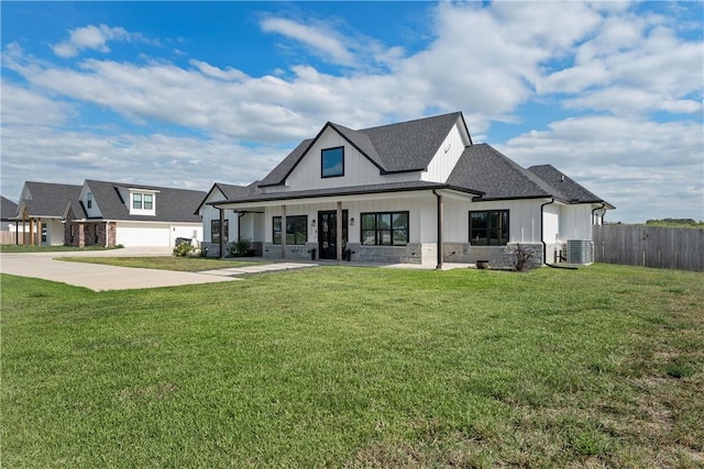 view of front of home featuring cooling unit, a front lawn, a porch, and a garage