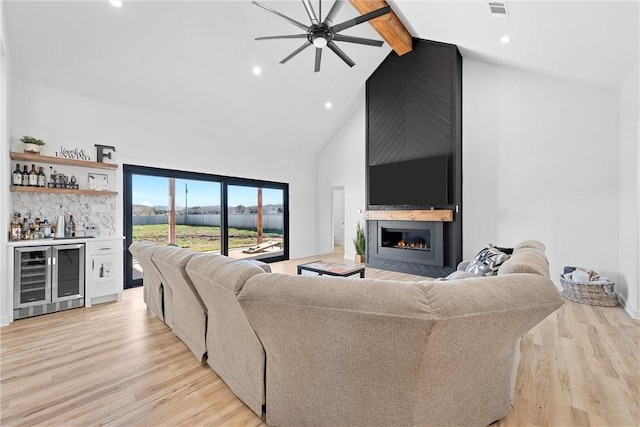 living room with beamed ceiling, light wood-type flooring, wine cooler, and indoor bar