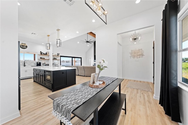 dining space featuring light hardwood / wood-style flooring, plenty of natural light, and lofted ceiling