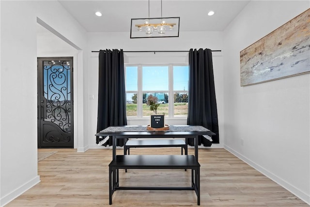 dining space featuring light wood-type flooring and a chandelier