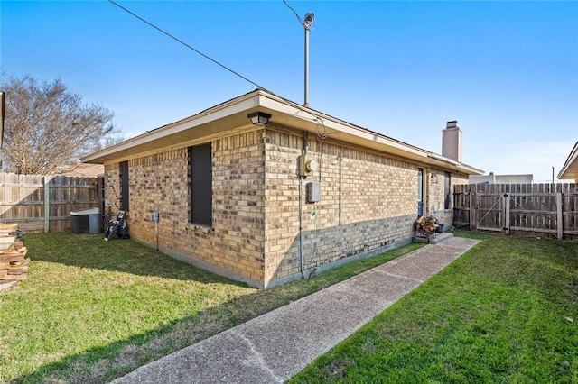 view of side of property with central AC and a lawn