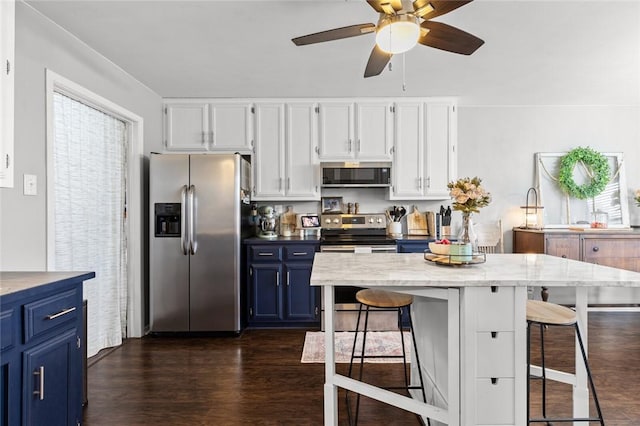 kitchen featuring stainless steel appliances, a kitchen breakfast bar, white cabinets, blue cabinets, and dark hardwood / wood-style flooring