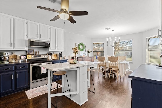 kitchen with blue cabinetry, white cabinetry, hanging light fixtures, stainless steel appliances, and a kitchen bar