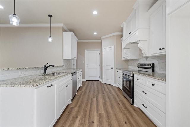 kitchen with hanging light fixtures, white cabinetry, sink, and stainless steel appliances