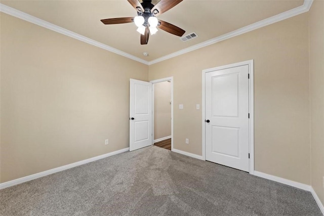 unfurnished bedroom featuring ceiling fan, crown molding, and carpet floors