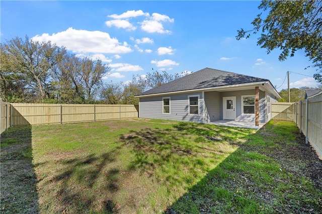 rear view of house featuring a lawn and a patio