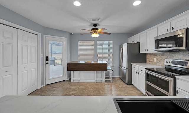 kitchen with white cabinetry, tasteful backsplash, stainless steel appliances, and ceiling fan