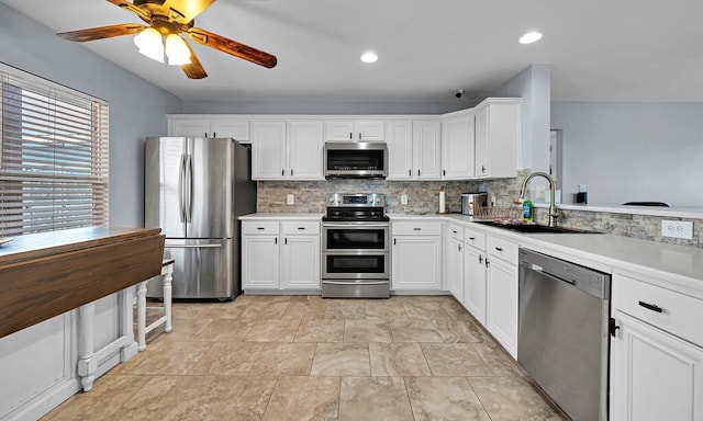 kitchen featuring sink, white cabinets, decorative backsplash, ceiling fan, and stainless steel appliances