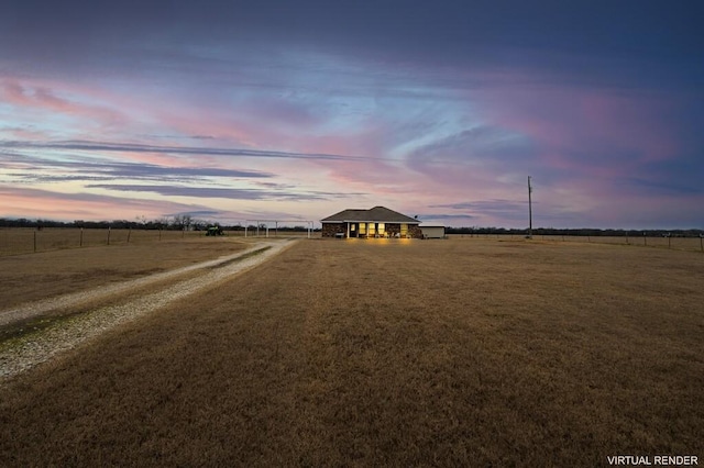 view of front of home with a rural view and a yard