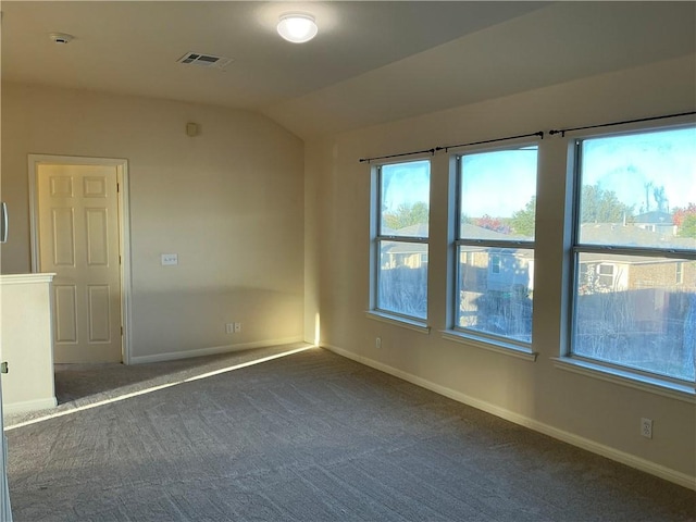 carpeted empty room featuring lofted ceiling