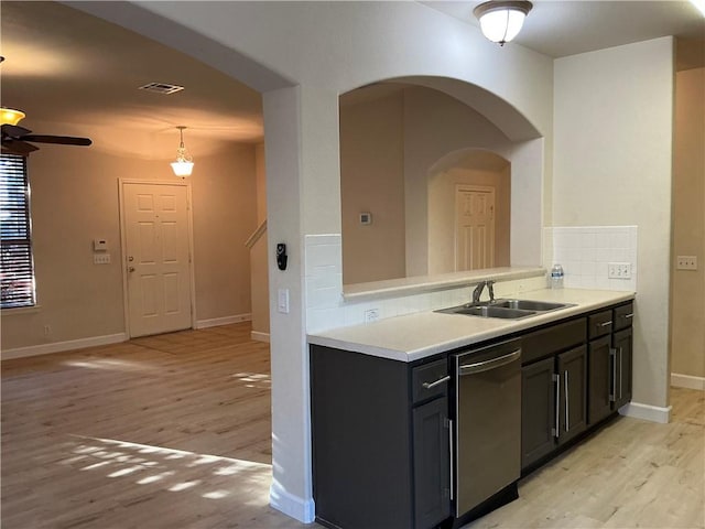 kitchen featuring dishwasher, sink, backsplash, pendant lighting, and light hardwood / wood-style floors