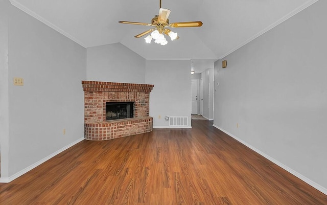 unfurnished living room with lofted ceiling, a brick fireplace, ornamental molding, hardwood / wood-style flooring, and ceiling fan