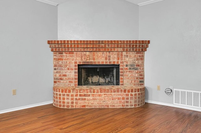 details with hardwood / wood-style flooring, crown molding, and a brick fireplace