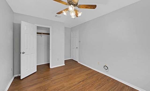 unfurnished bedroom with a closet, dark hardwood / wood-style floors, and ceiling fan