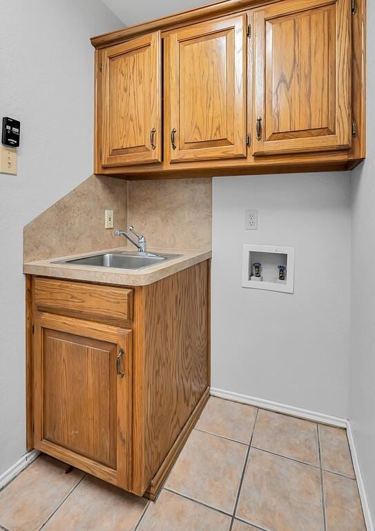 washroom featuring cabinets, sink, hookup for a washing machine, and light tile patterned floors