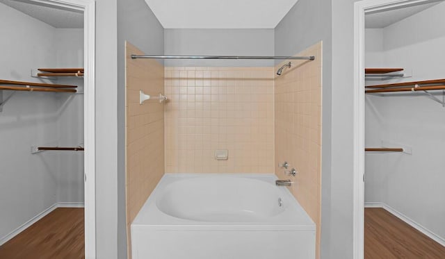 bathroom with tiled shower / bath and wood-type flooring