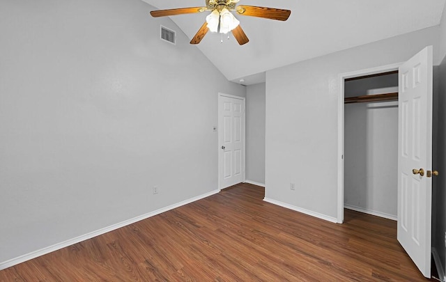 unfurnished bedroom with ceiling fan, lofted ceiling, dark hardwood / wood-style flooring, and a closet