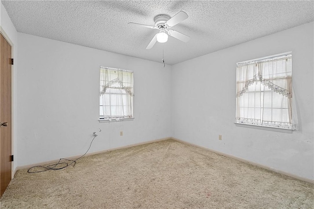 spare room featuring carpet, ceiling fan, and a textured ceiling