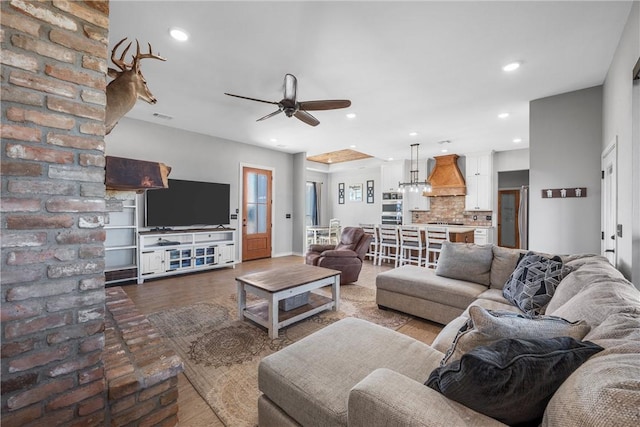 living room featuring hardwood / wood-style floors and ceiling fan