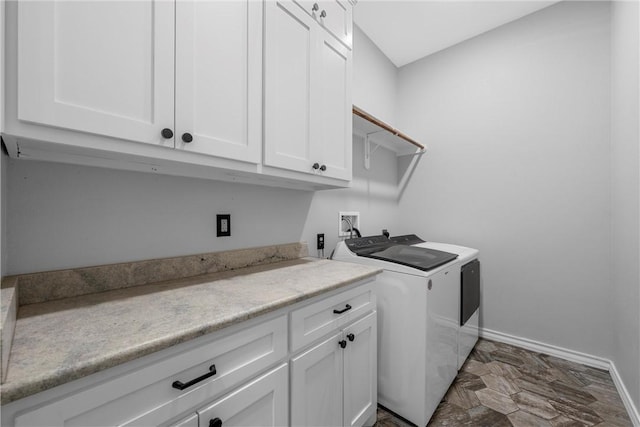 clothes washing area with separate washer and dryer and cabinets