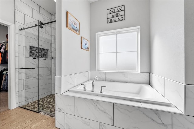 bathroom with hardwood / wood-style flooring and separate shower and tub