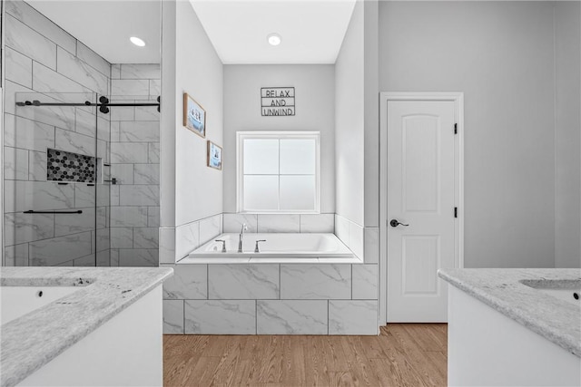 bathroom featuring vanity, independent shower and bath, and hardwood / wood-style flooring