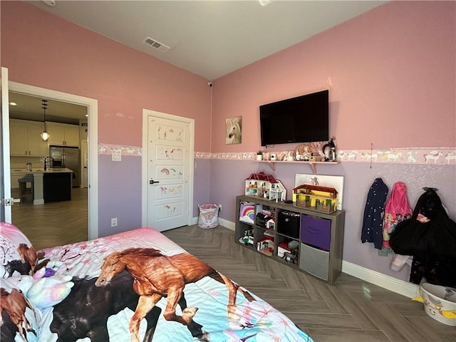 bedroom featuring stainless steel fridge and dark parquet flooring