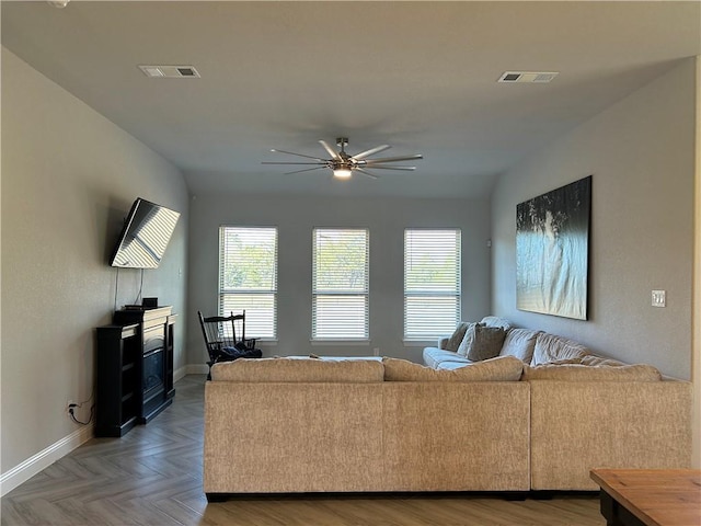 living room featuring ceiling fan and parquet floors