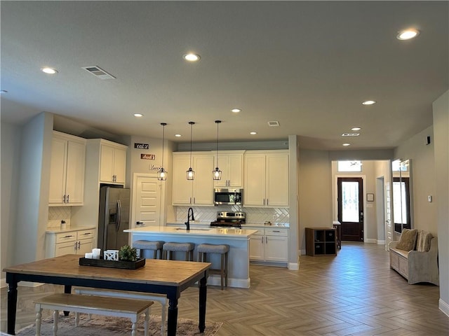 kitchen with white cabinets, decorative light fixtures, and appliances with stainless steel finishes