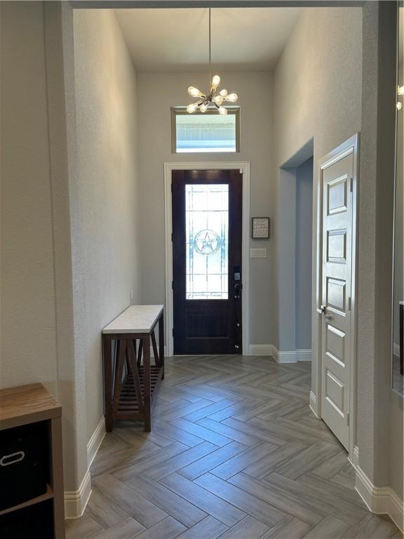 foyer featuring a chandelier, a high ceiling, and light parquet flooring