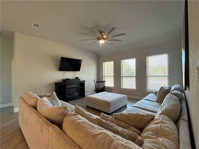 living room featuring ceiling fan and a wood stove