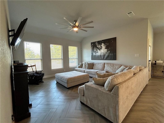 living room featuring ceiling fan and dark parquet floors