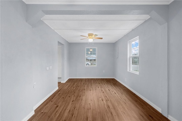 unfurnished room with beamed ceiling, wood-type flooring, and ceiling fan