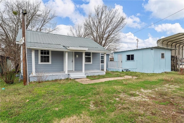 view of front of home featuring a front lawn, a porch, and a carport