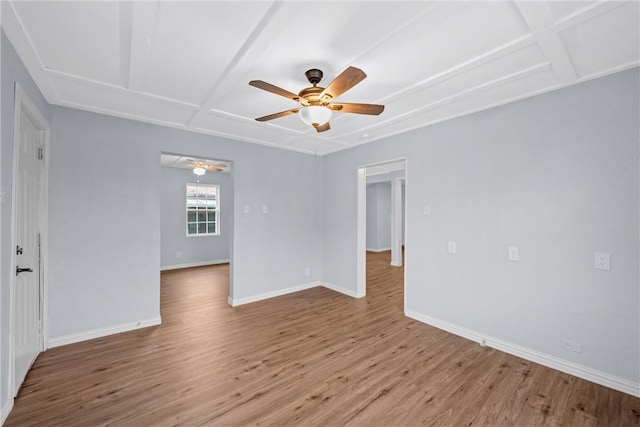 spare room with ceiling fan, coffered ceiling, and light wood-type flooring