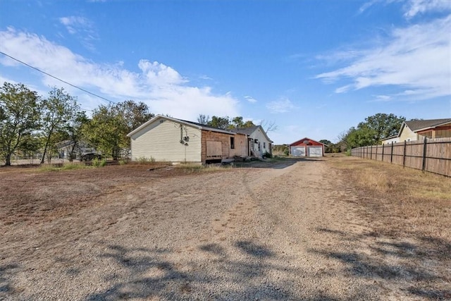 exterior space with a garage and an outbuilding