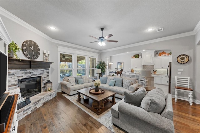 living room with ornamental molding, a textured ceiling, and dark wood-type flooring