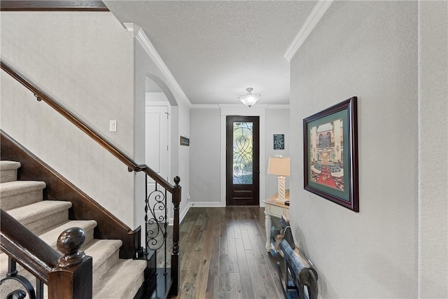 entrance foyer featuring crown molding, wood-type flooring, and a textured ceiling