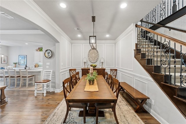 dining space with hardwood / wood-style flooring and crown molding