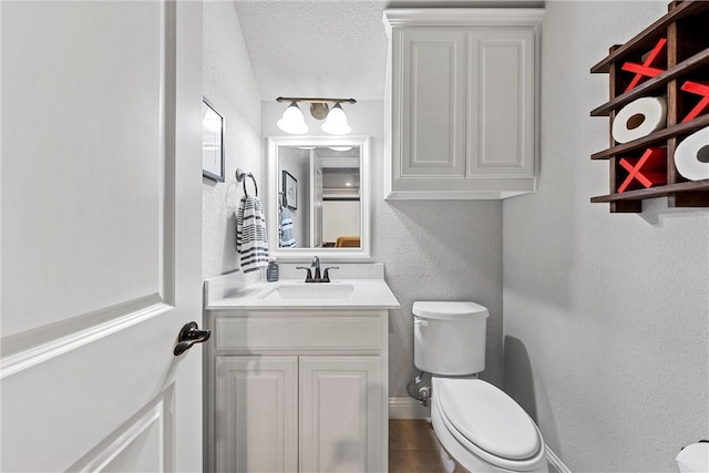 bathroom featuring tile patterned flooring, vanity, a textured ceiling, and toilet