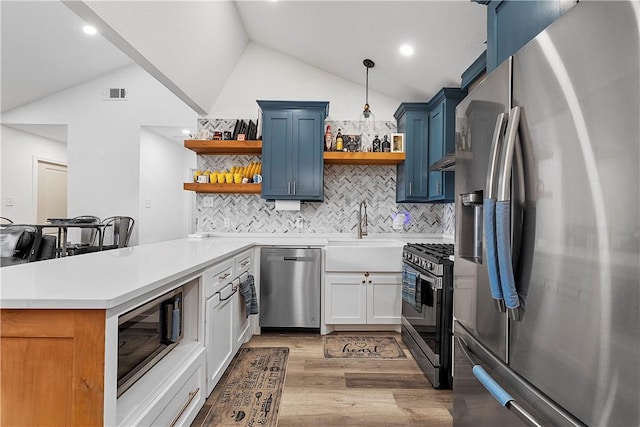 kitchen featuring pendant lighting, white cabinetry, stainless steel appliances, backsplash, and kitchen peninsula