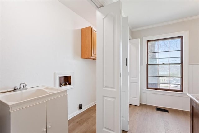 clothes washing area with a healthy amount of sunlight, cabinet space, light wood-type flooring, and hookup for a washing machine