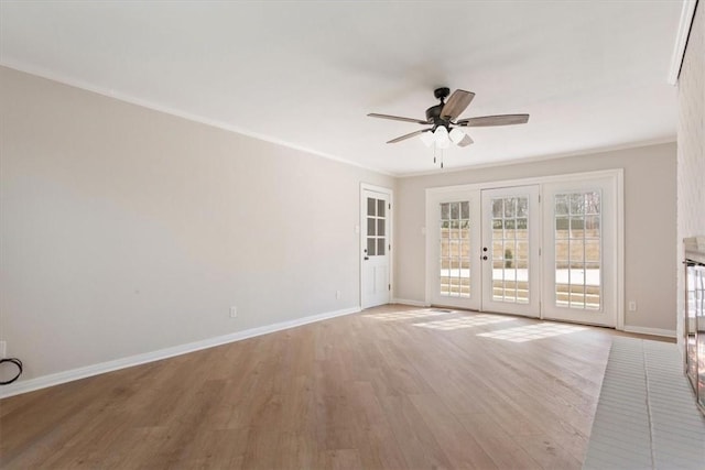 spare room featuring a ceiling fan, baseboards, french doors, light wood finished floors, and crown molding