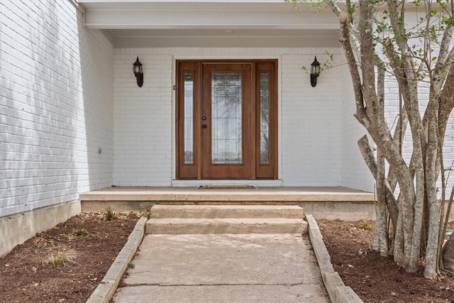 property entrance featuring brick siding and a porch