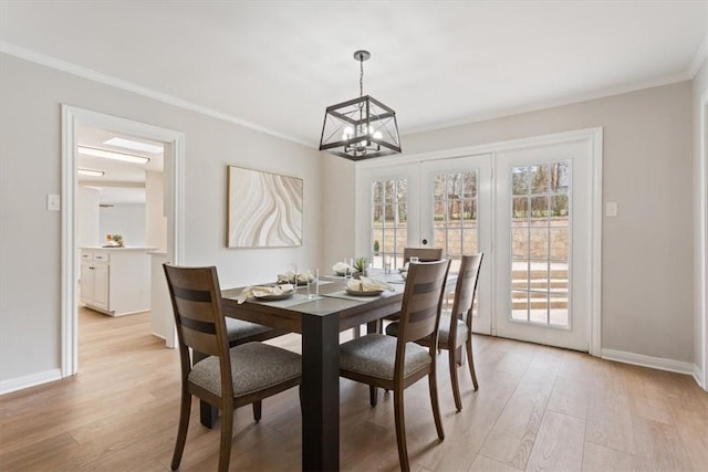 dining area with light wood-style floors, french doors, crown molding, and baseboards