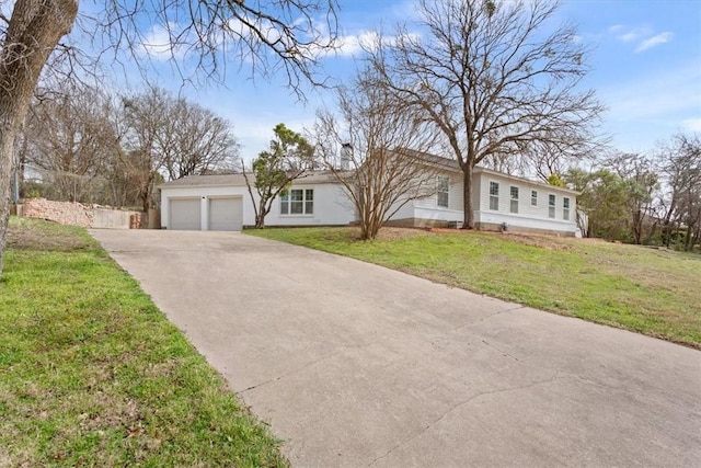 ranch-style home featuring a garage, concrete driveway, and a front yard