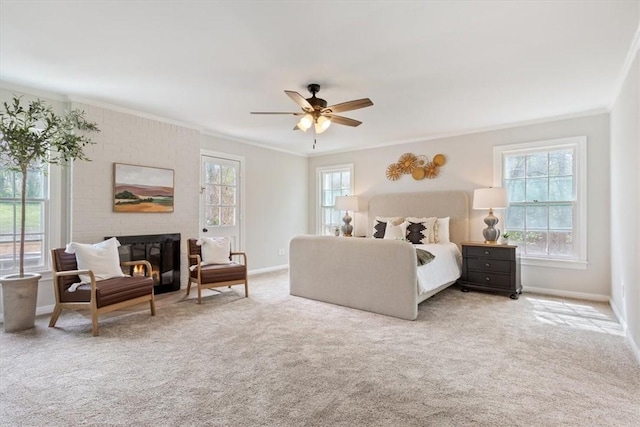 carpeted bedroom featuring ornamental molding, a brick fireplace, baseboards, and a ceiling fan