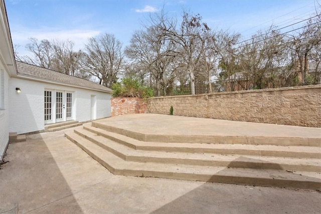 view of yard featuring fence, a patio, and french doors