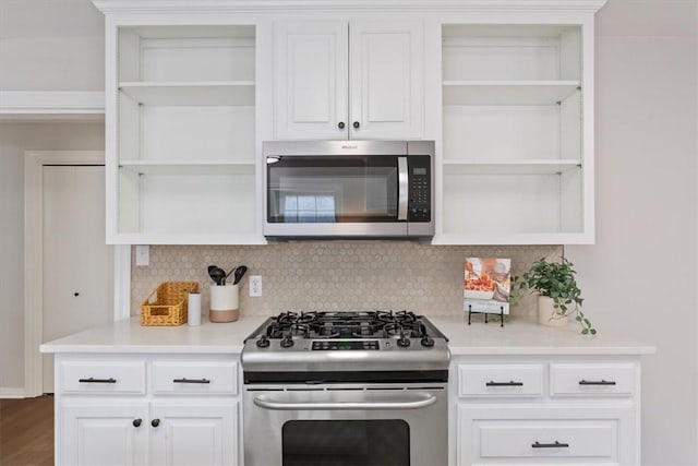 kitchen featuring open shelves, decorative backsplash, light countertops, and stainless steel appliances